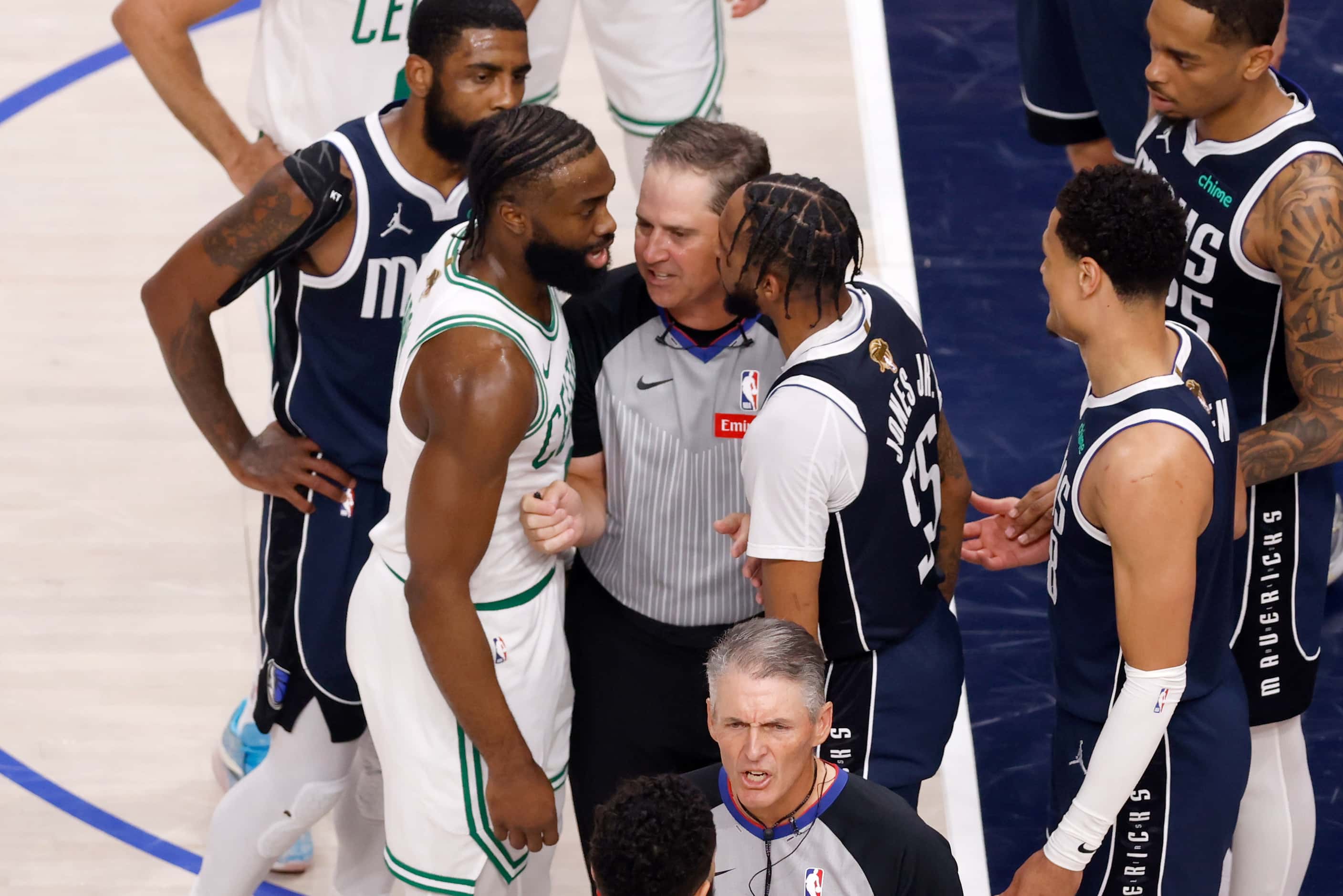 A referee separates Boston Celtics guard Jaylen Brown (7) and Dallas Mavericks forward...