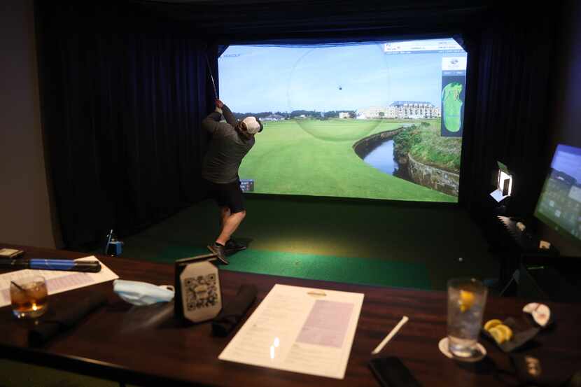 PJ Spielman plays virtual golf in one of five simulators at Daylight Golf on Thursday,...