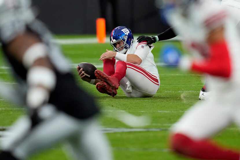 New York Giants quarterback Daniel Jones grimaces after a sack during the first half of an...