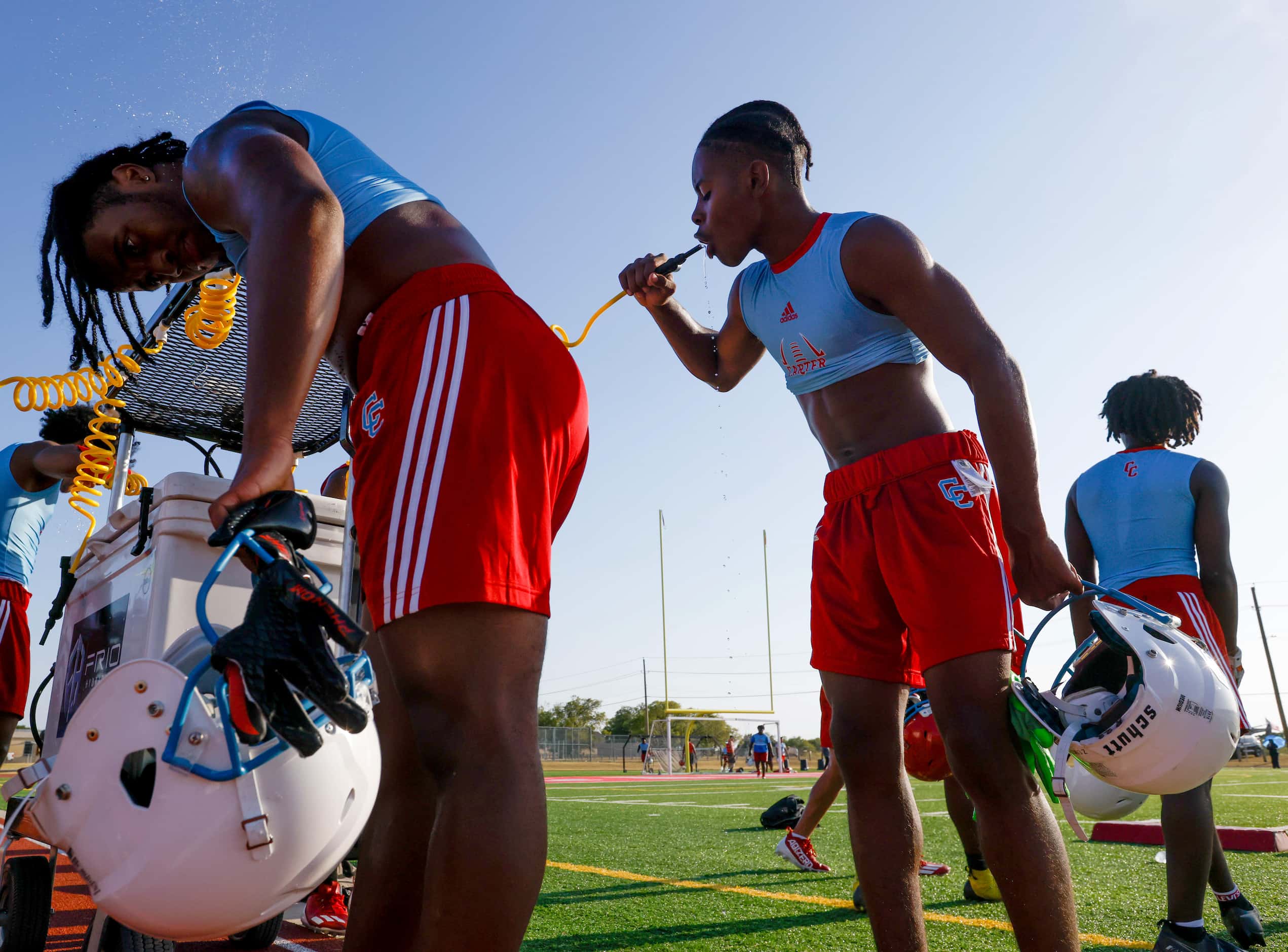 Water sprays from the spouts of a watering station at Carter High School as football players...