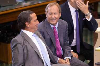 Texas Attorney General Ken Paxton (center) sits with his defense attorneys Tony Buzbee...