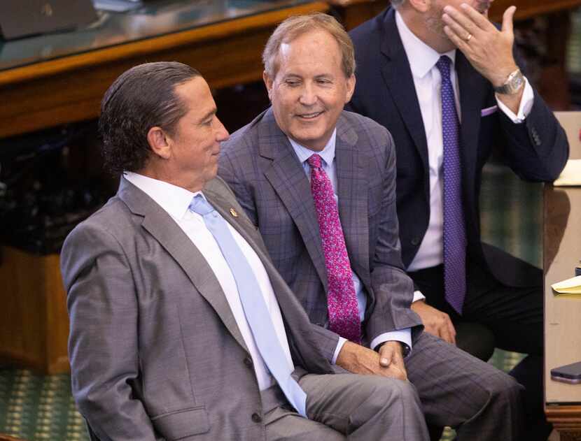 Texas Attorney General Ken Paxton (center) sits with his defense attorneys Tony Buzbee...