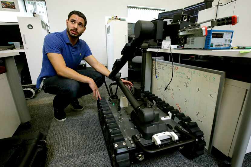 Software engineer Nicholas Otero talks to a colleague about features on a Centaur robot at...