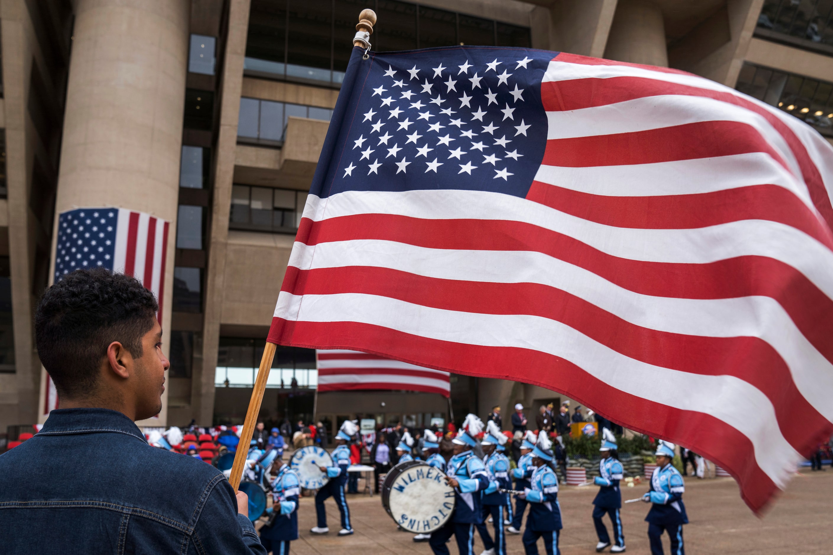 John Melinda, Jr., holds a flag as he watches as the Wilmer Hutchins band passes City Hall...