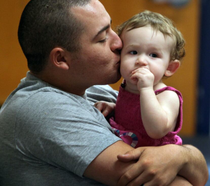 Army E4 James Torres gave daughter Khloe a kiss as they watched events on Wednesday.