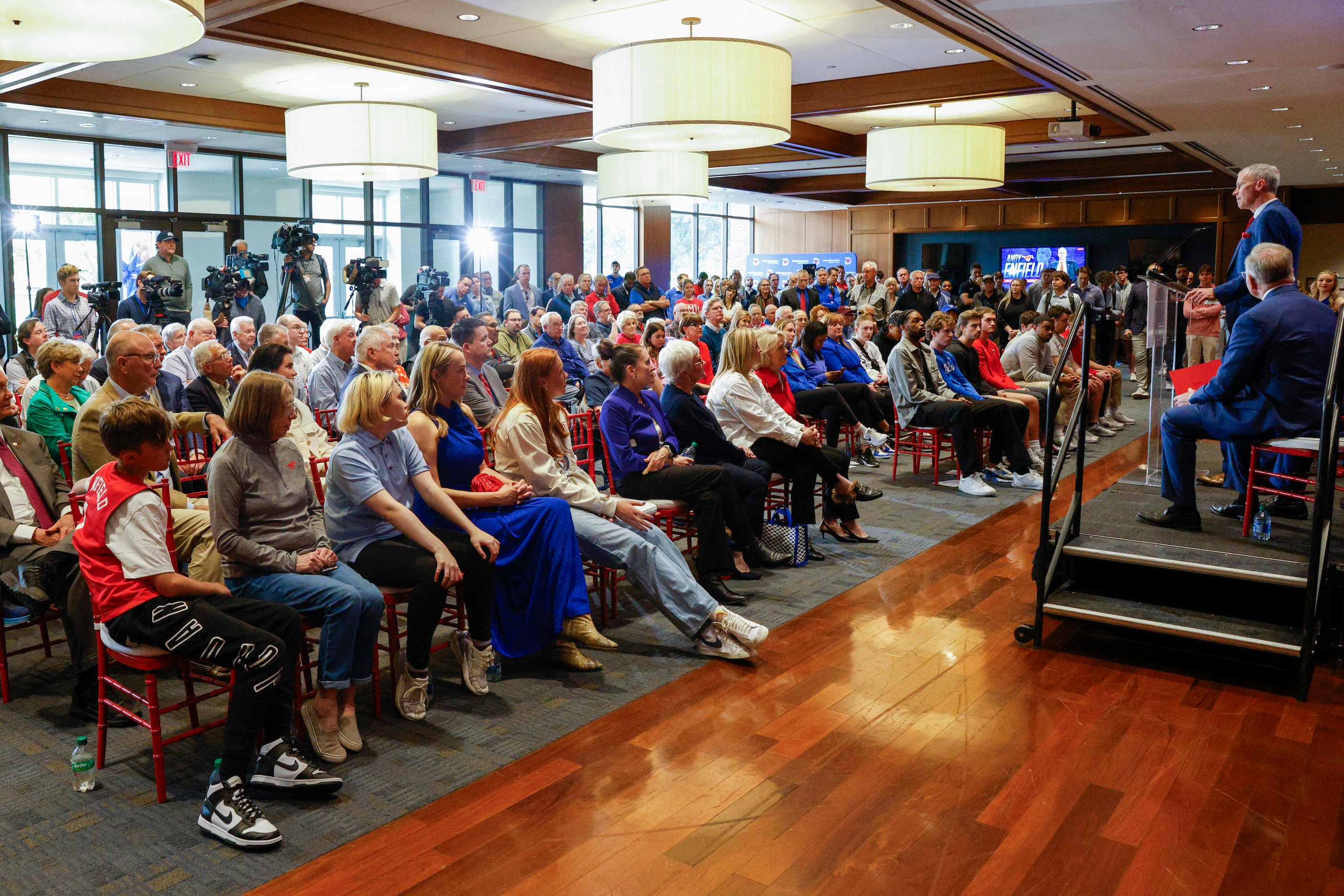 Attendees listen as SMU head men's basketball coach Andy Enfield speaks during an...