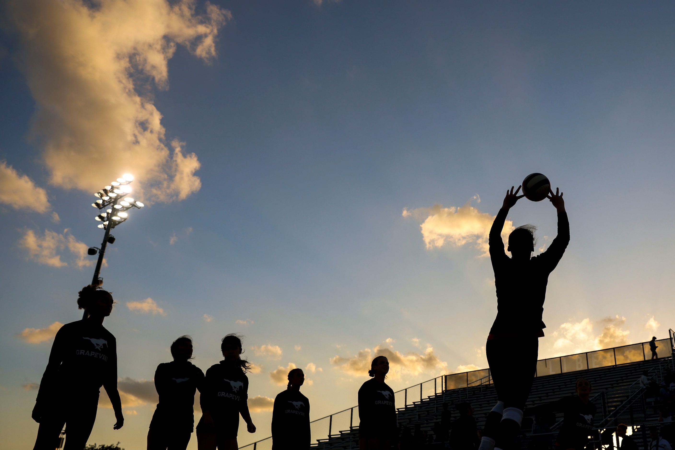 Grapevine High players warm up ahead of an outdoor volleyball game against Liberty Christian...