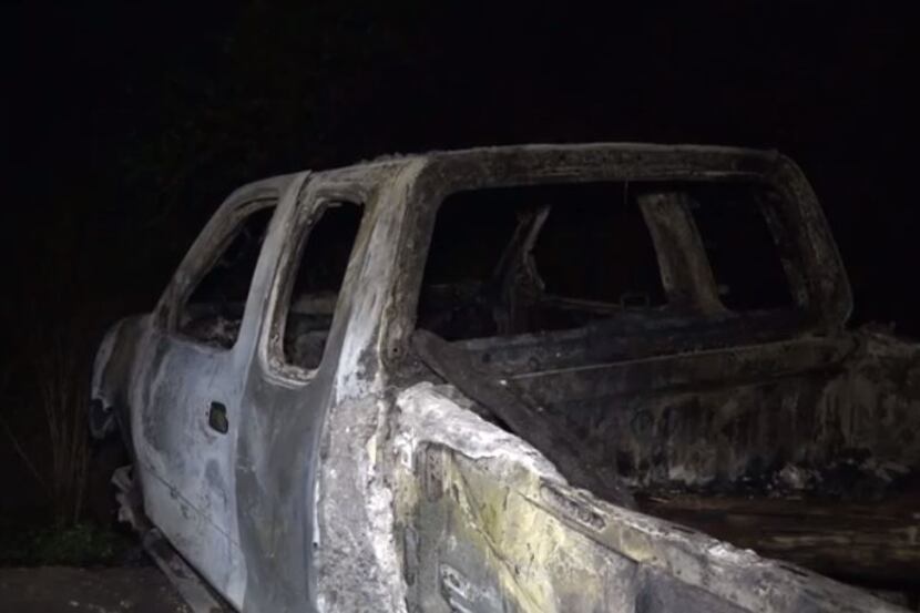 A charred pickup sits in a wooded area in Fort Worth after it caught fire Monday night. The...