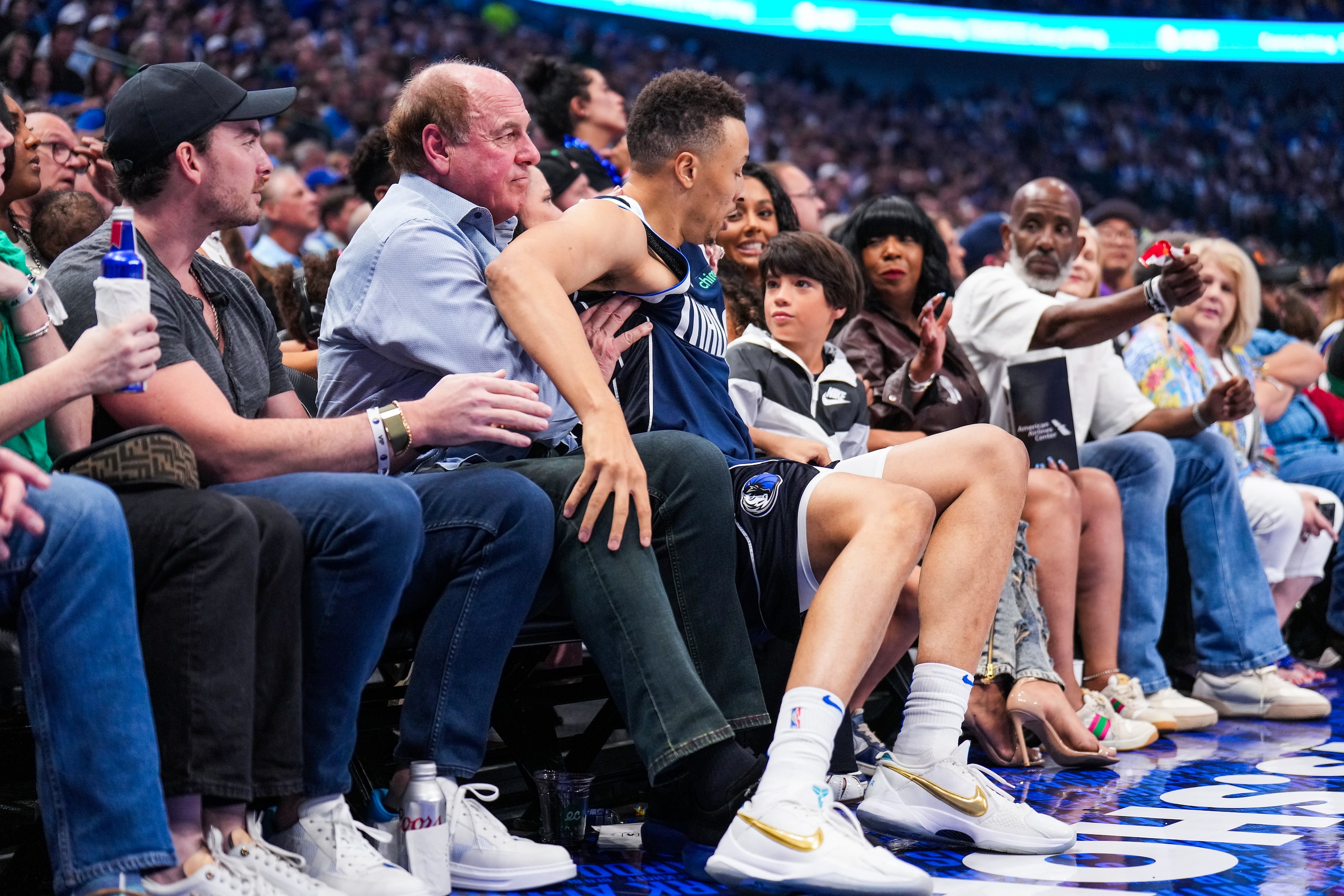 Dallas Mavericks guard Dante Exum falls into the first row of the crowd during the first...