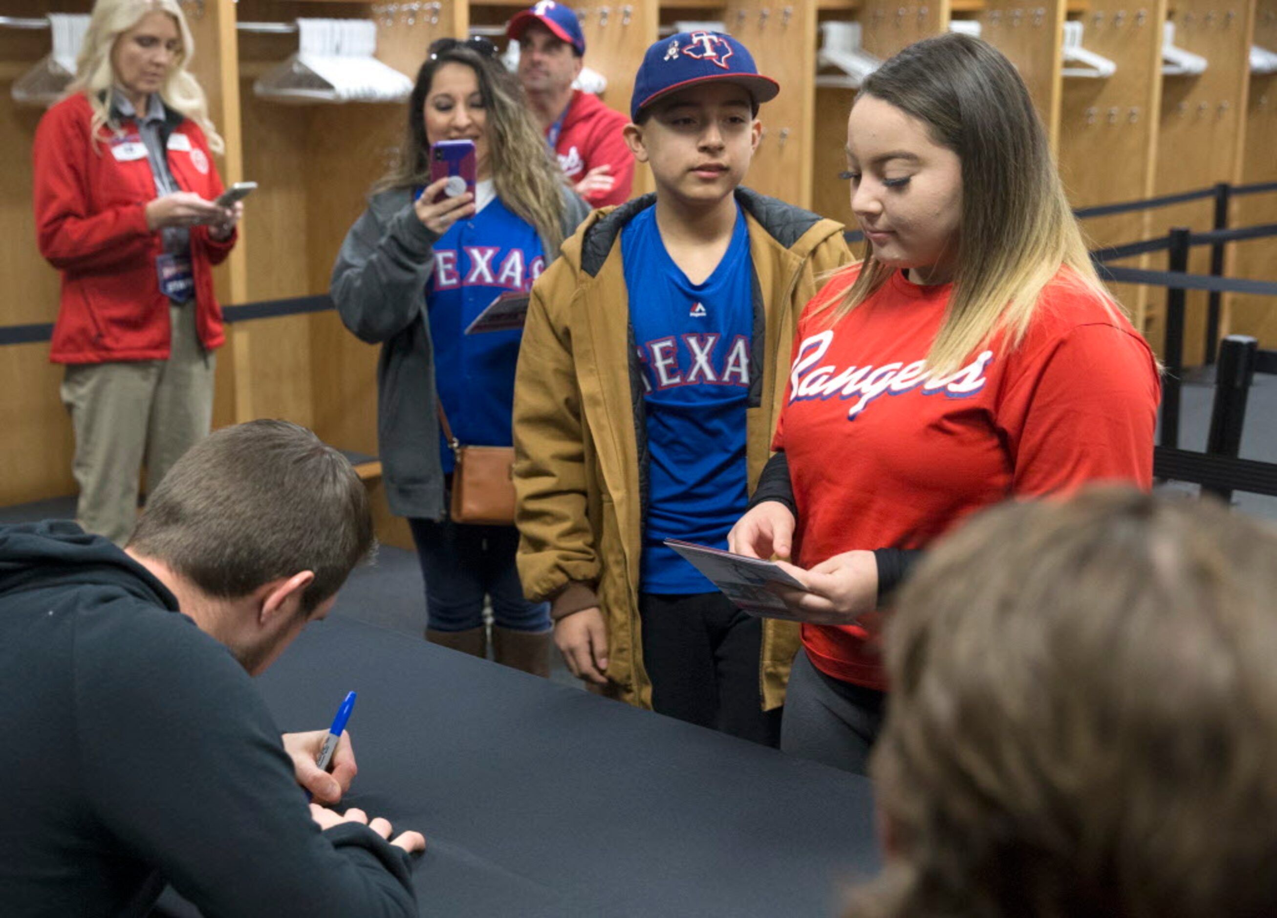 Elena Luera of Fort Worth watches as Texas Ranger Jeffrey Springs signs her cellular phone...