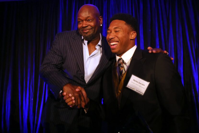 Emmitt Smith, left, shakes hands with Arlington Martin's defensive end Myles Garrett, who...