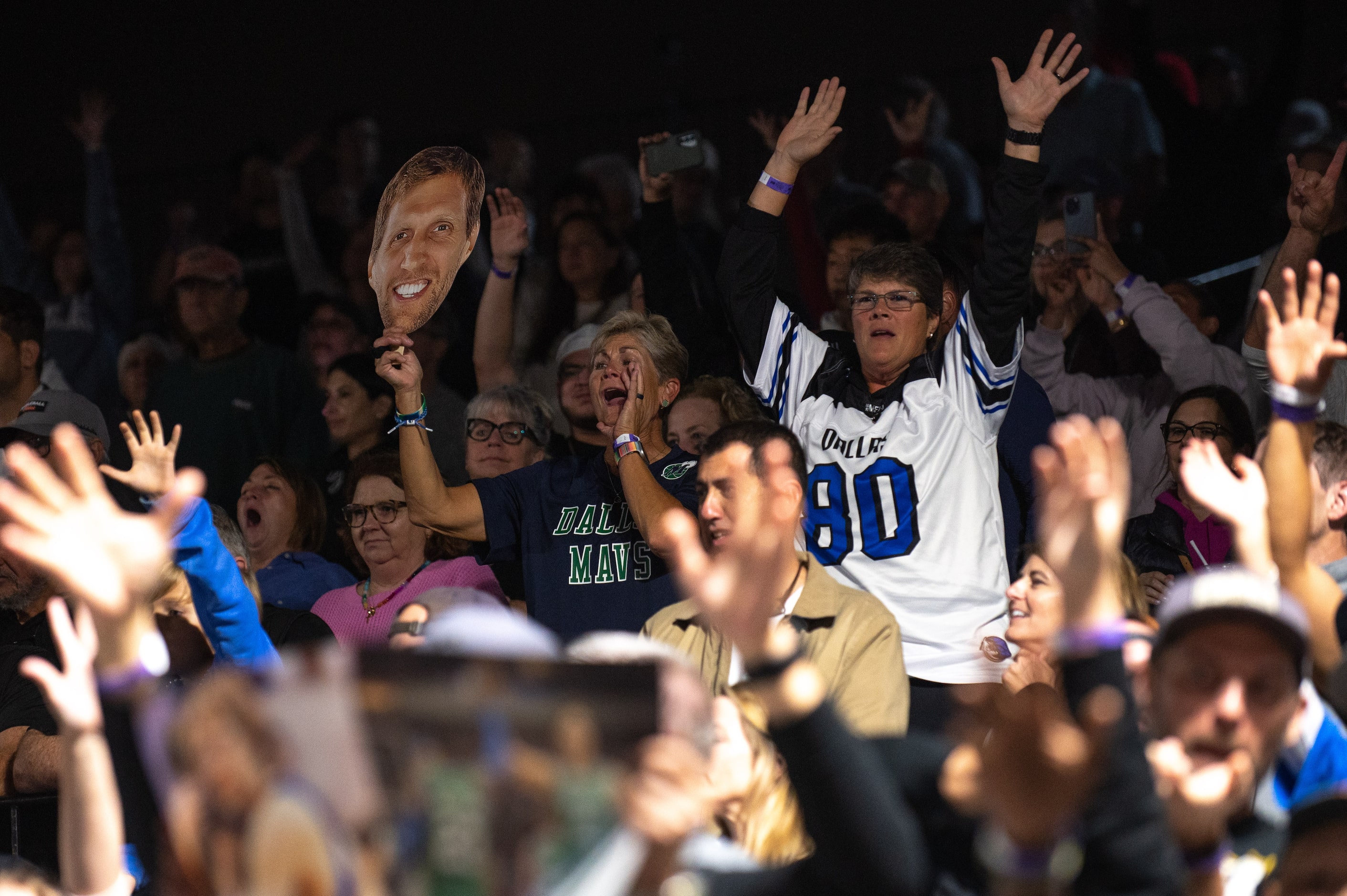 Dallas Mavericks fans scream and chat for Dirk Nowitzki, not pictured, as he tossed free...