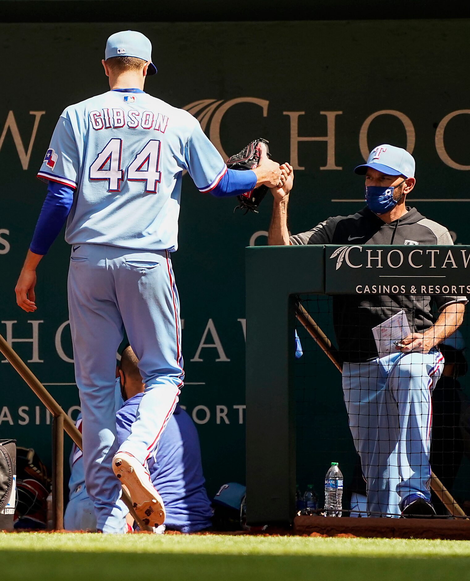 Texas Rangers pitcher Kyle Gibson gets a fist bump from manager Chris Woodward after...