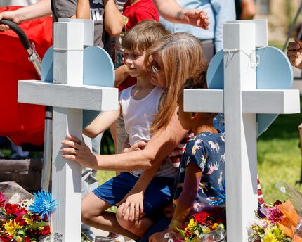 Angela Turner, 49, comforts her nephew Bruce Mathis, 8, at a cross for his sister Miranda...