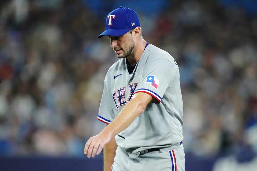 El abridor de los Rangers de Texas estira el brazo tras salir del juego contra los Azulejos...