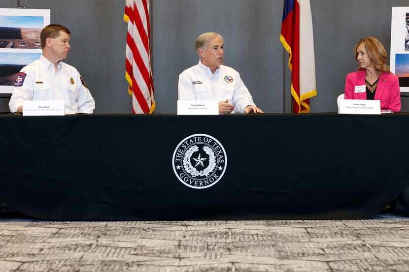 Texas Gov. Greg Abbott (center) speaks alongside Chief Nim Kidd, Texas Division of Emergency...