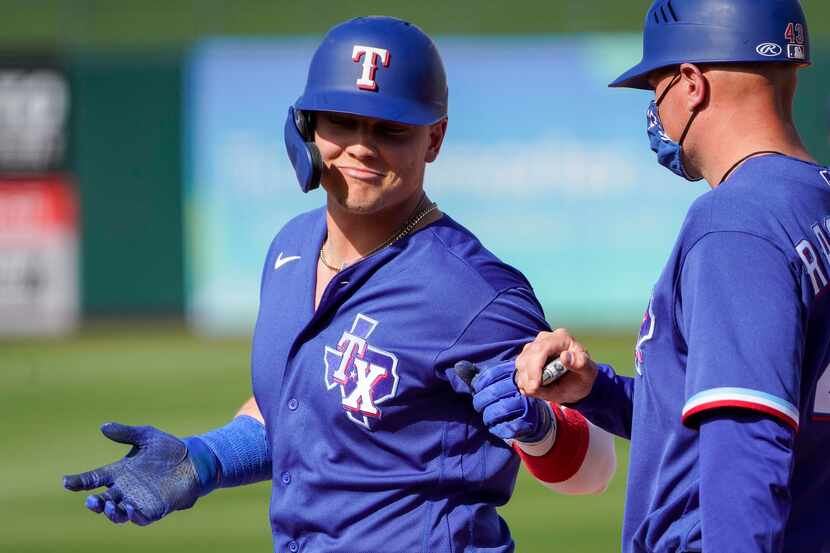 Texas Rangers outfielder Steele Walker celebrates with first base coach Corey Ragsdale after...