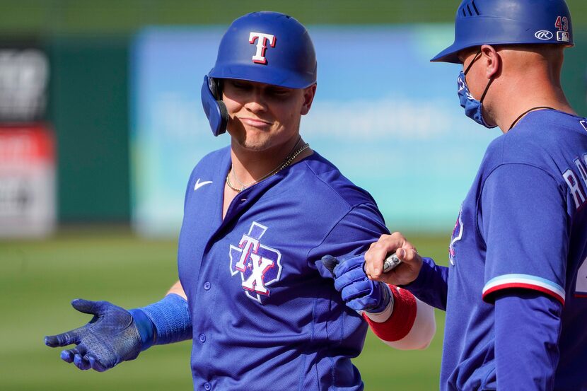 Texas Rangers outfielder Steele Walker celebrates with first base coach Corey Ragsdale after...