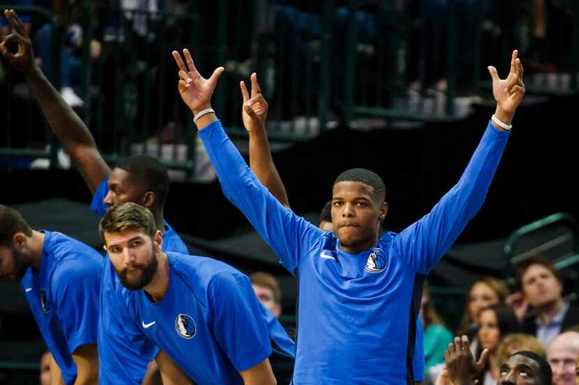 Dallas Mavericks guard Dennis Smith Jr. celebrates on the bench after a teammate hit a...