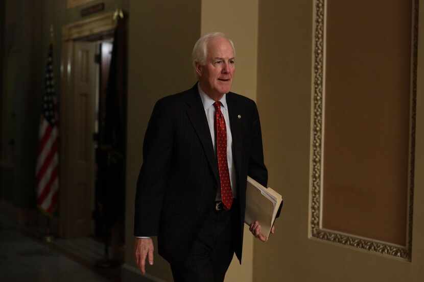 Sen. John Cornyn walks down a hallway at the U.S. Capitol after a meeting in the office of...