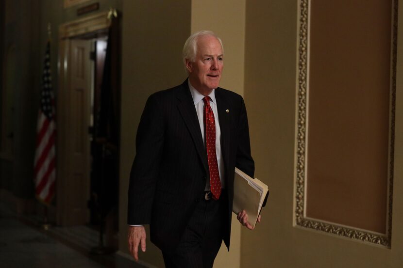 Sen. John Cornyn walks down a hallway at the U.S. Capitol after a meeting in the office of...