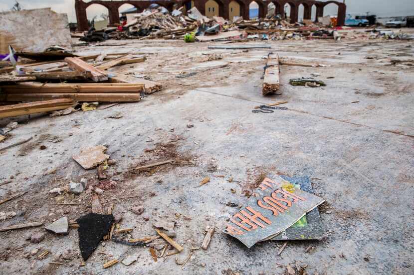 A pamphlet reading "Jesus Help" lays among the debris at the site of Primera Iglesia...