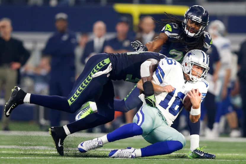 Dallas Cowboys quarterback Matt Cassel (16) grimaces as he is hit by Seattle Seahawks strong...