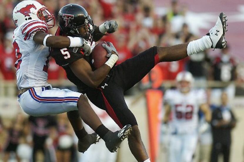 Texas Tech's Michael Crabtree, right, tries to hang on to a pass under the pressure of SMU's...