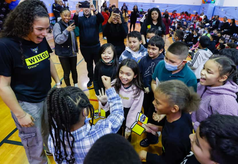 Veronica Burton (left), Dallas Wings guard, cheers on third-graders Vin’cynthia Williams...