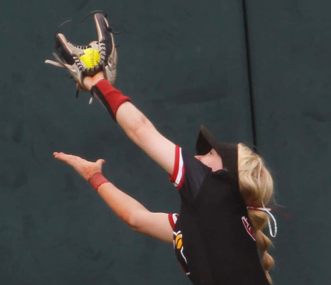 Melissa center fielder Emily Johnson (3) leaps to pull in a long drive at the wall to end...