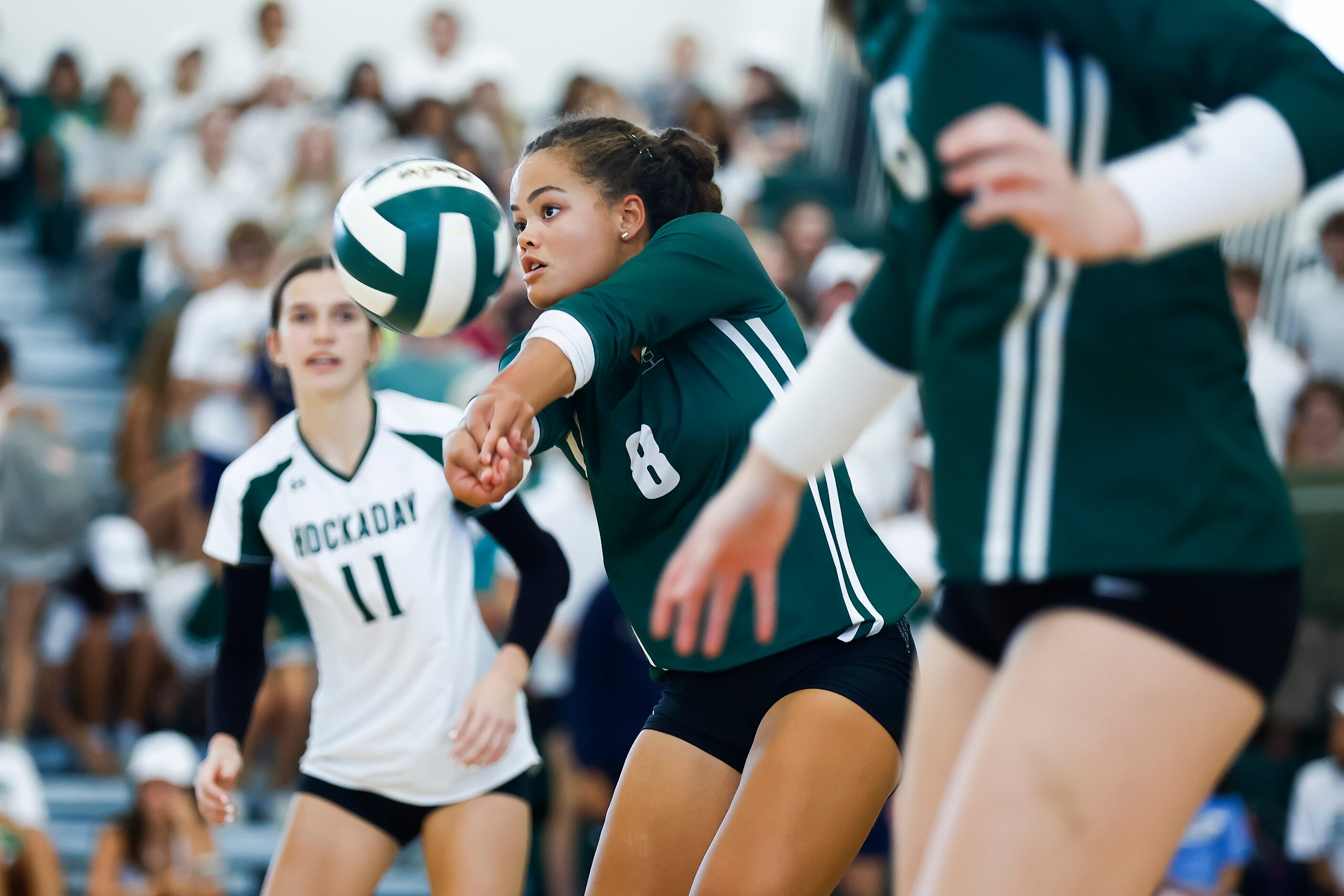 Hockaday senior outside hitter Avery Jackson, center, digs the ball during a high school...