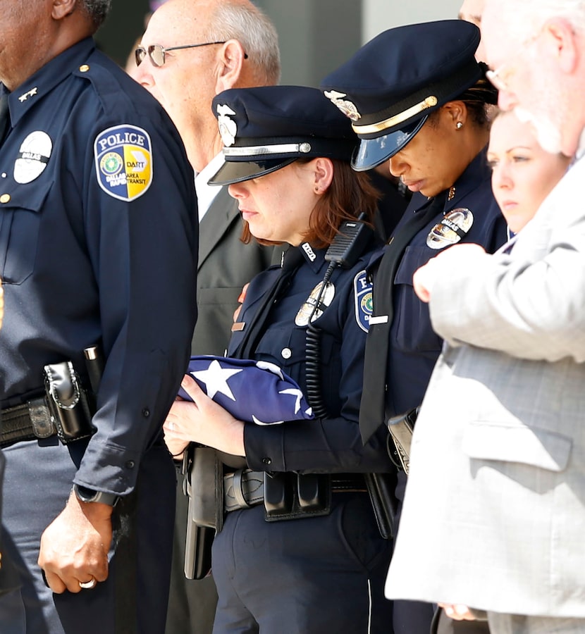 DART Officer Emily Thompson holds the flag that was draped over the casket of her husband,...