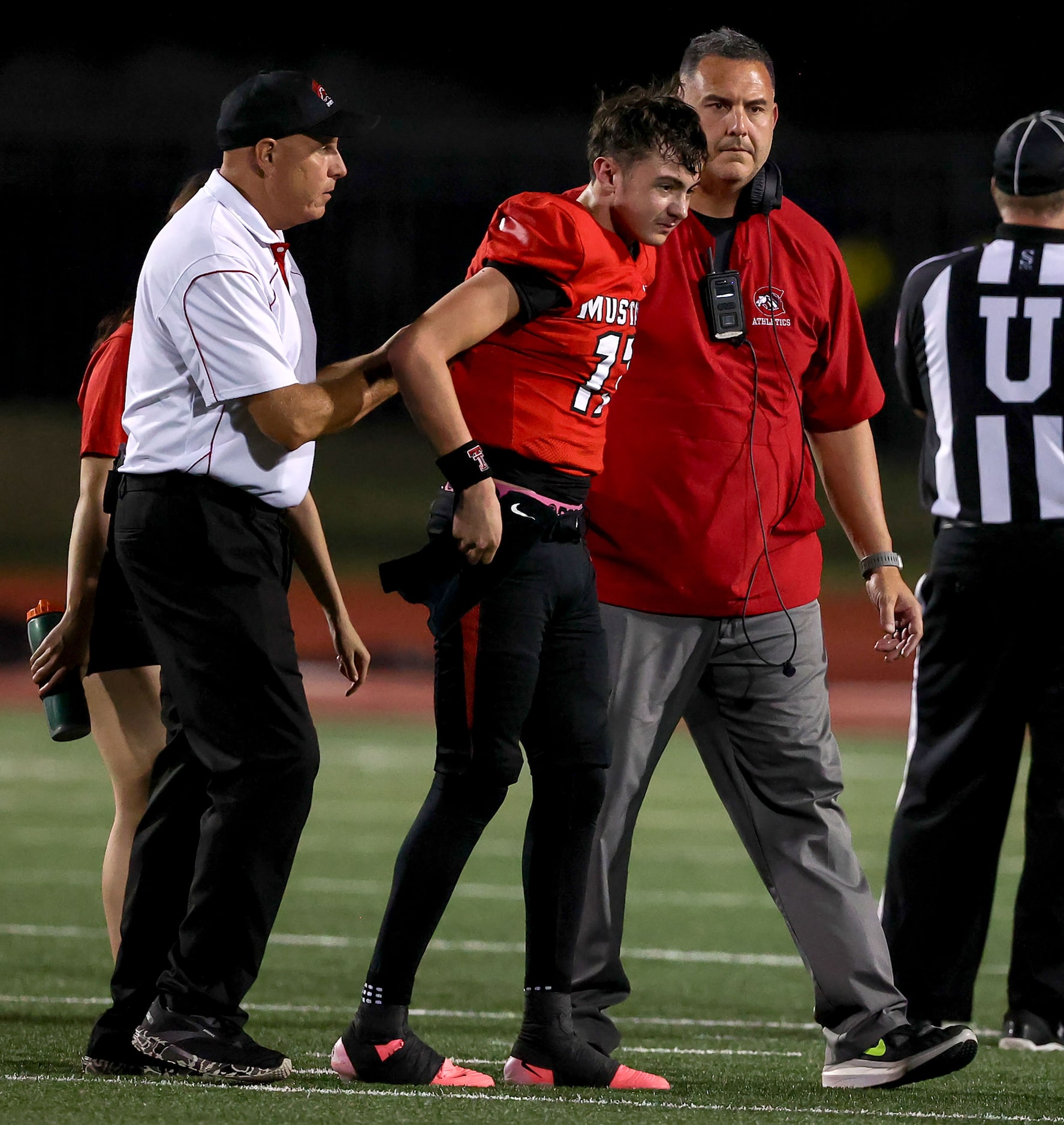 Creekview quarterback Cason Garcia (17) is helped off the field by his head coach Dusty...