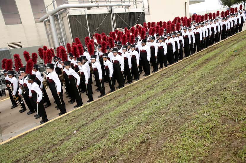 The Red Oak Mighty Hawk band waited next to freshly mowed, muddy grass before marching in...