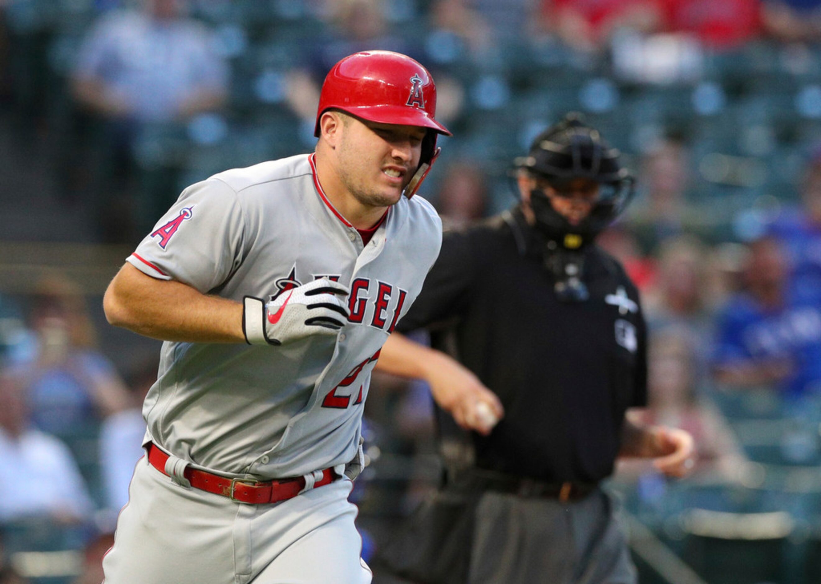 Los Angeles Angels' Mike Trout winces as he takes his base after being hit by a pitch in the...