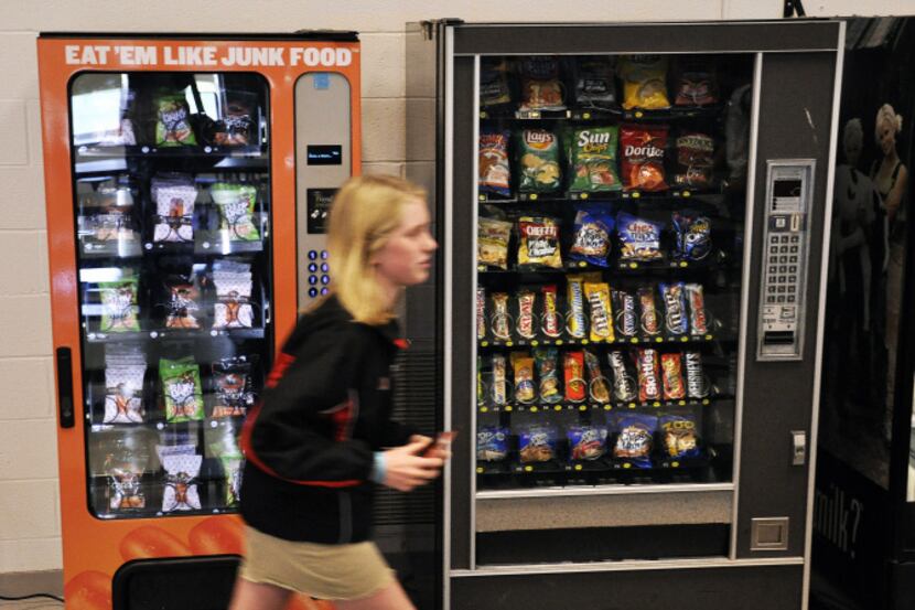 A student passes vending machines - including one filled with healthy options - during lunch...