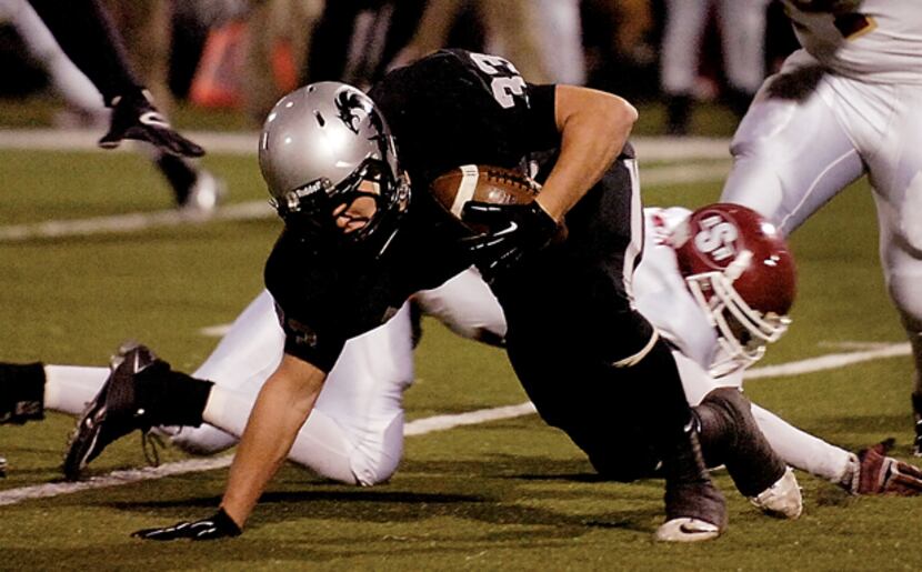 Denton Guyer running back Nate Maki (33) plants his arm to regain his balance after being...