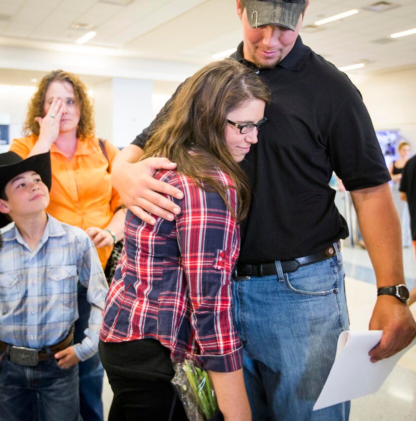 
Danielle Banks hugs her boyfriend Luke Burleson as her sister Michele Mackey and nephew Ben...