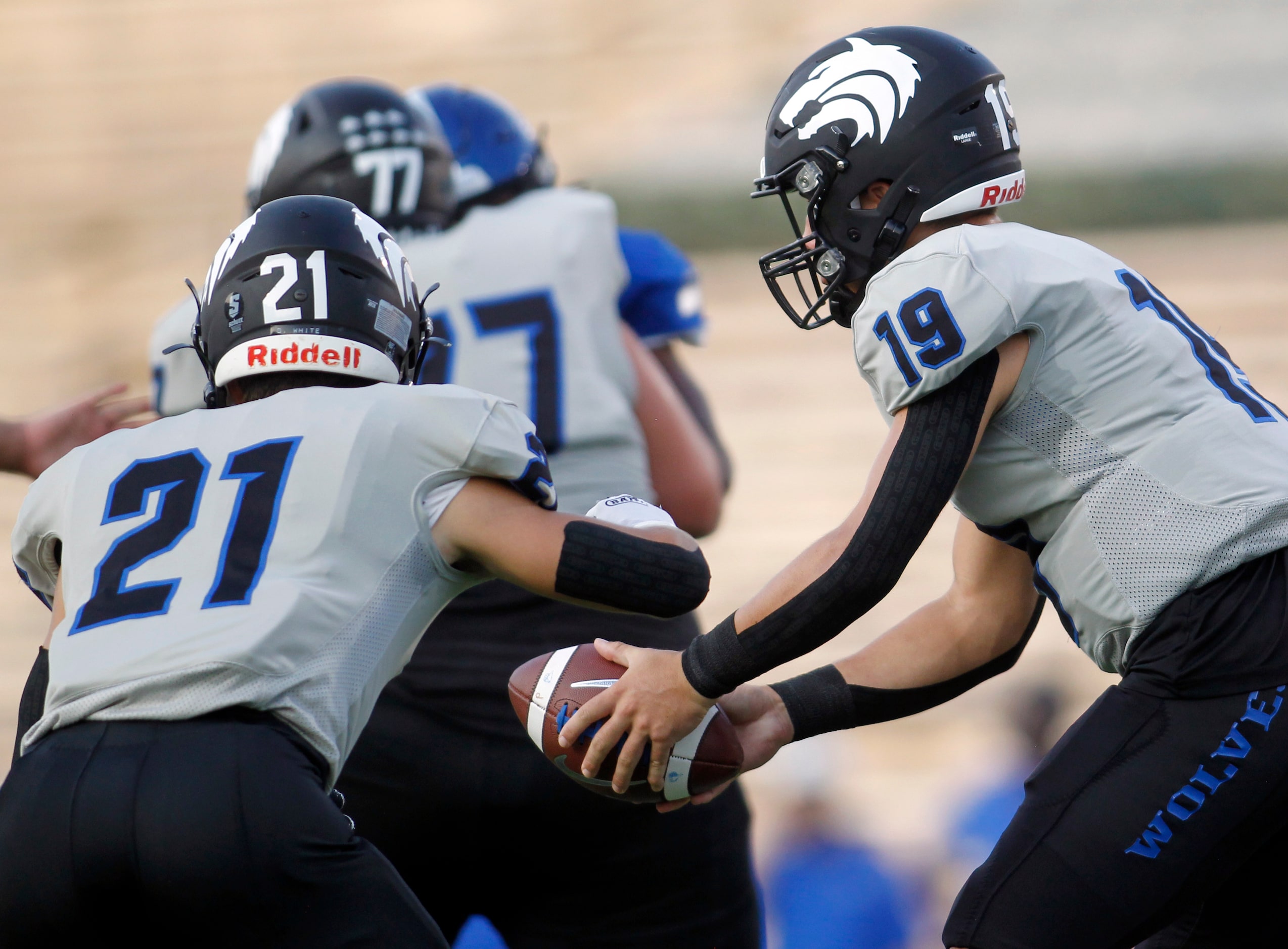 Plano West quarterback Vance Feuerbacher (19) hands the ball off to running back Dermot...