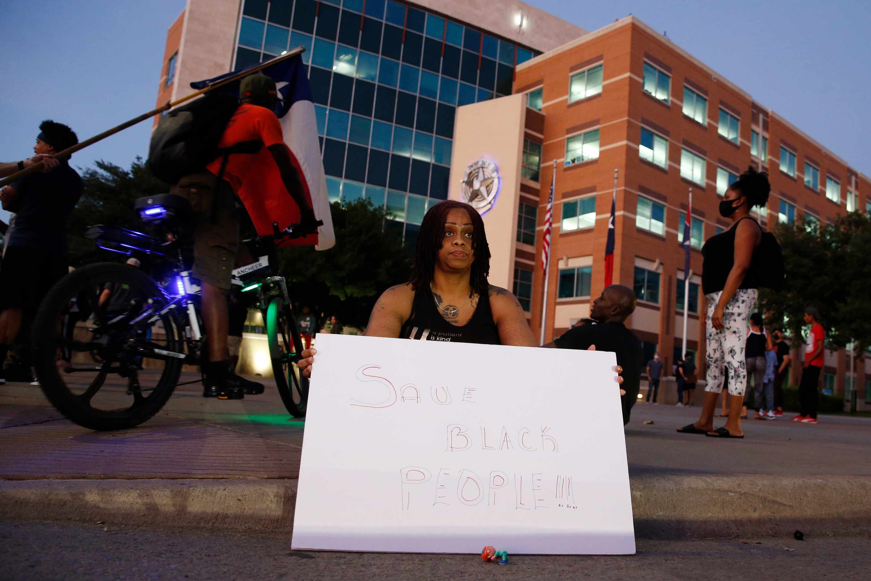 Chanel Speight of Dallas sits in front of the Dallas Police Department Headquarters during a...