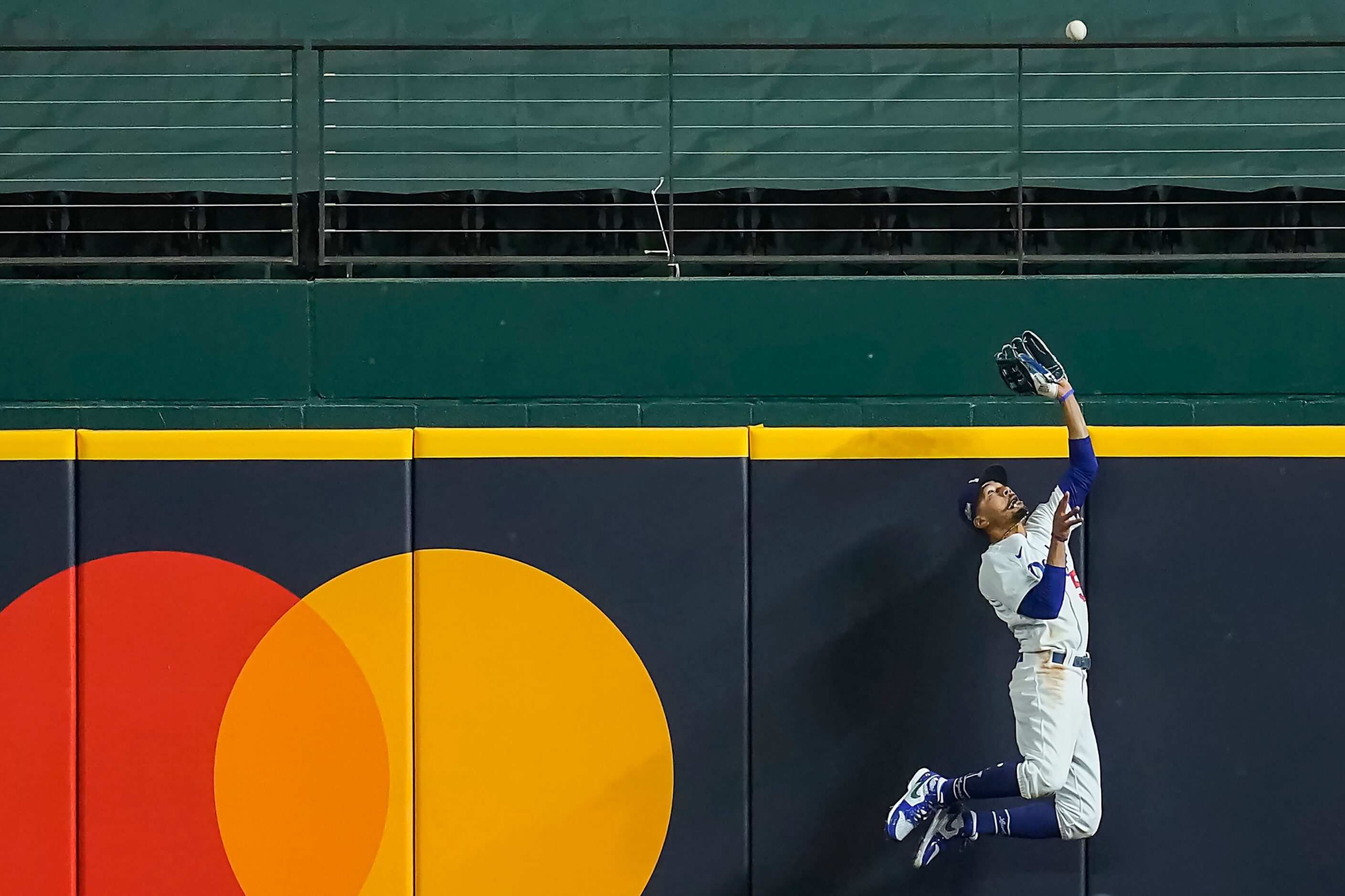 Los Angeles Dodgers right fielder Mookie Betts makes a leaping catch at the wall to take a...