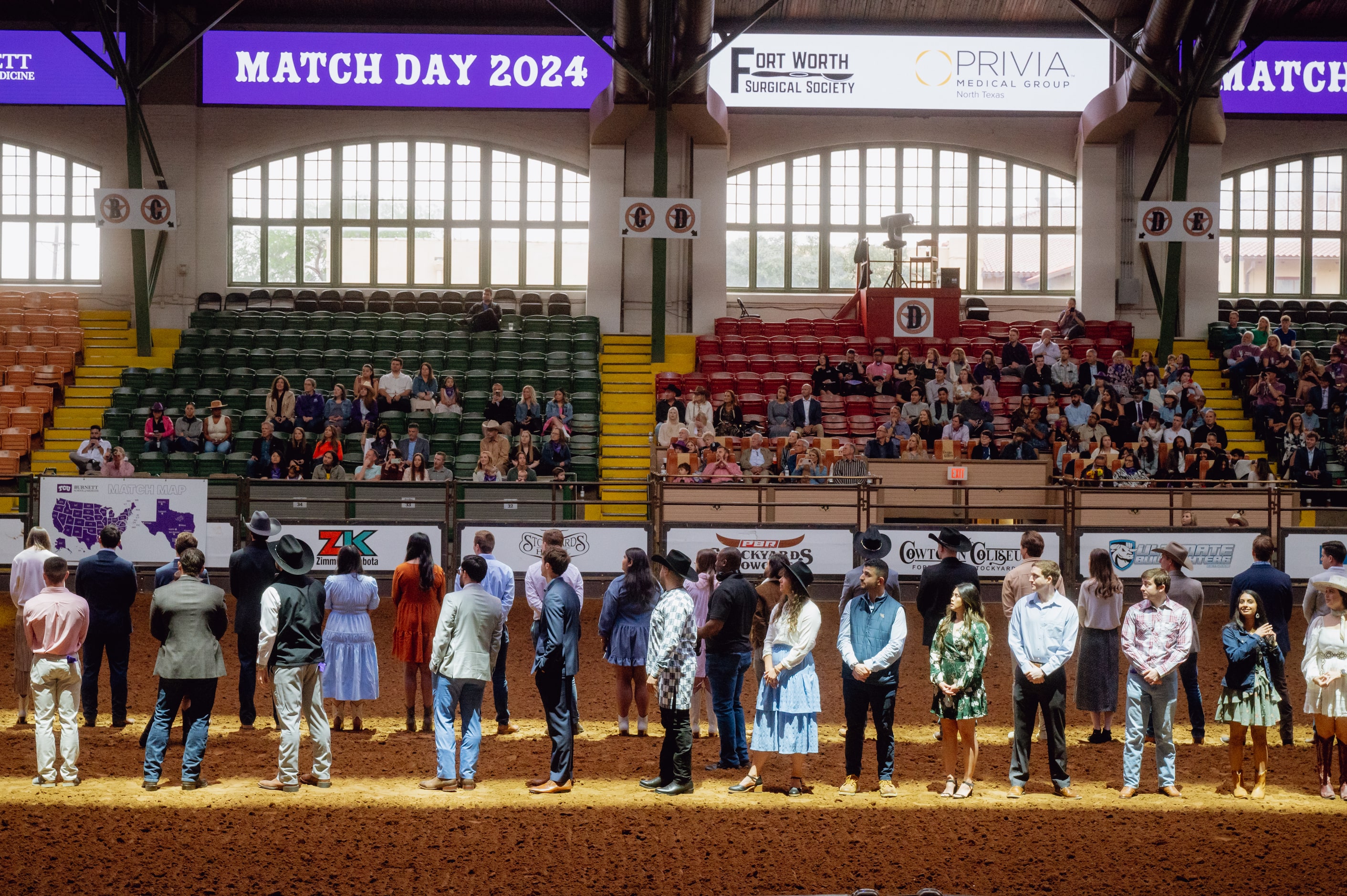 TCU medical students line up on arena floor at the Cowtown Coliseum in Fort Worth as they...