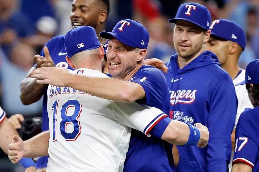 Texas Rangers pitcher Max Scherzer (facing hugs teammate Mitch Garver (18) as they celebrate...
