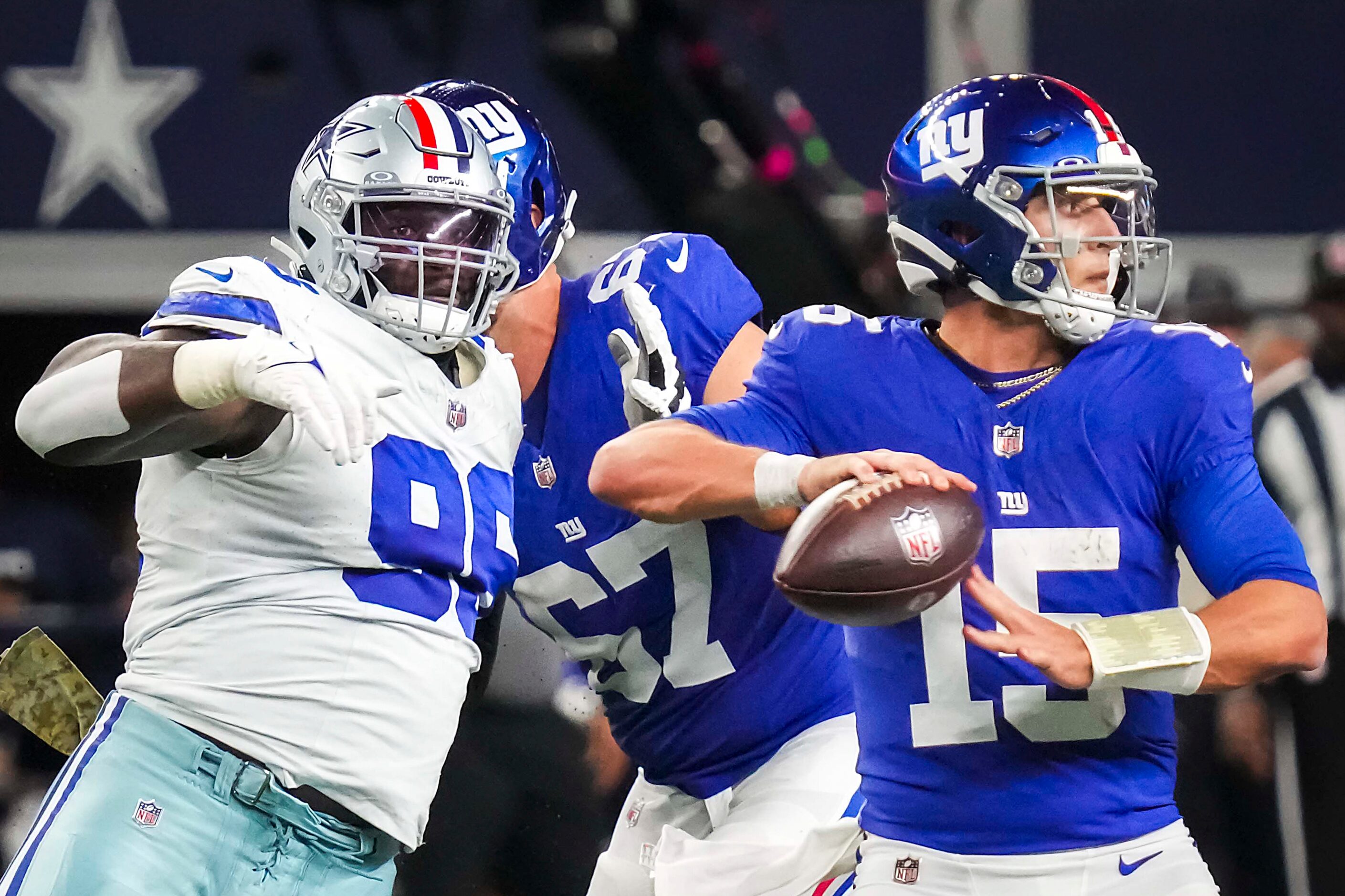 New York Giants quarterback Tommy DeVito (15) throws a pass under pressure from Dallas...