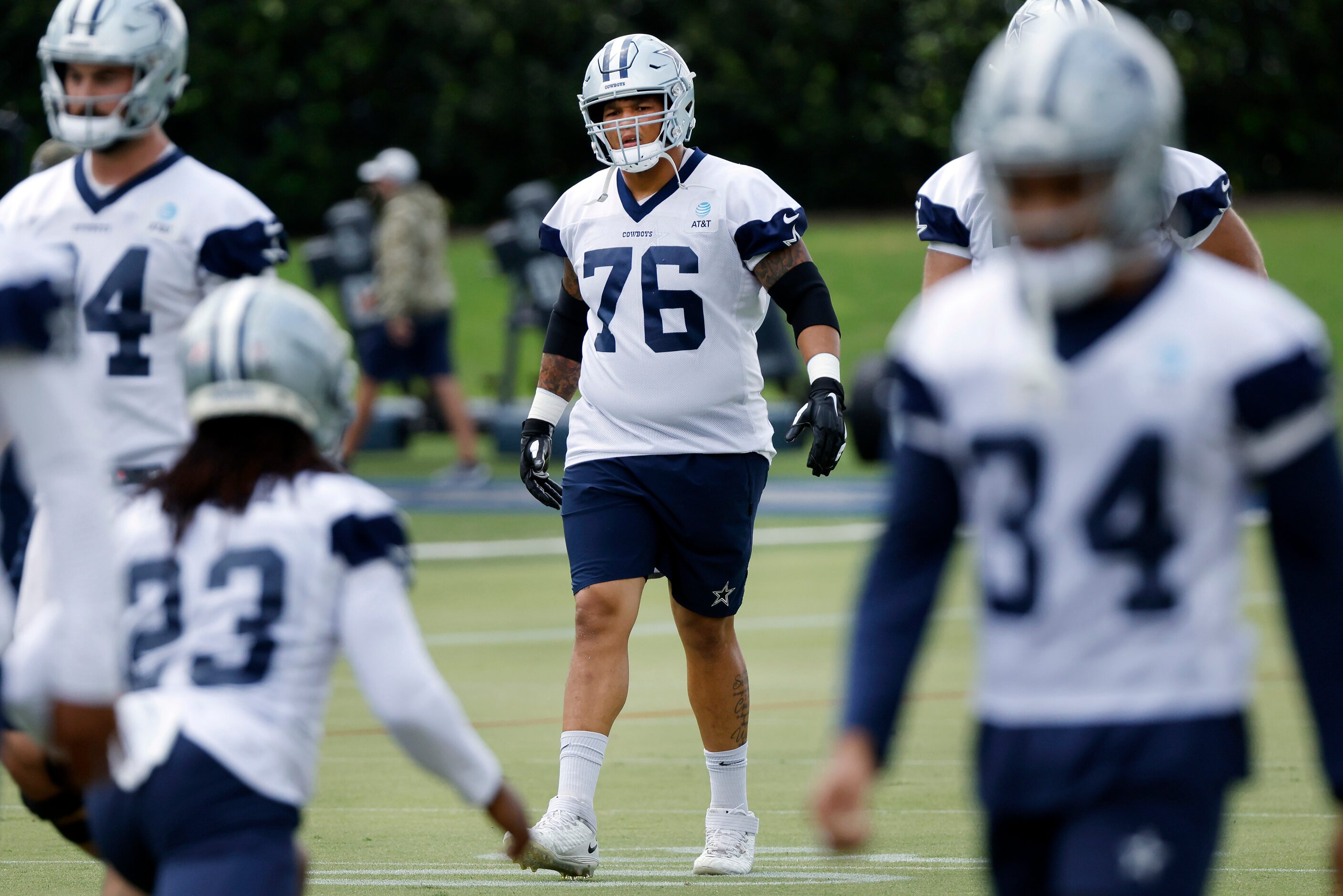 Dallas Cowboys practice squad offensive tackle Aviante Collins (76) runs through drills with...