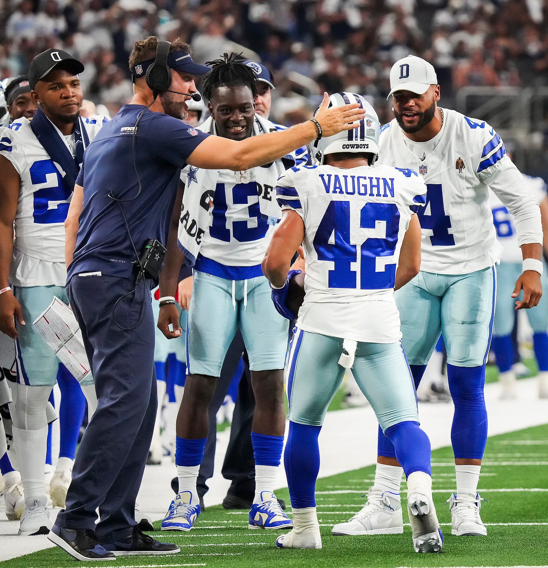 Dallas Cowboys running back Deuce Vaughn (42) celebrates with offensive coordinator Brian...