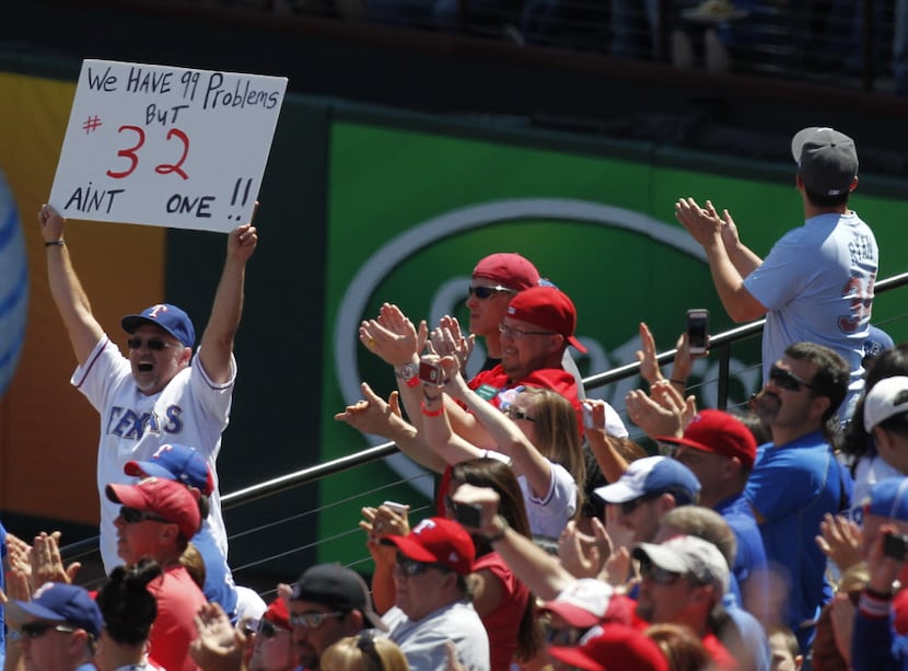 Texas Rangers fans celebrate after Los Angeles Angels left fielder Josh Hamilton (32) struck...