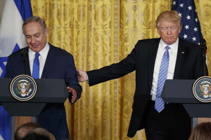 El presidente estadounidense Donald Trump toca el brazo del primer ministro israelí Benjamin...