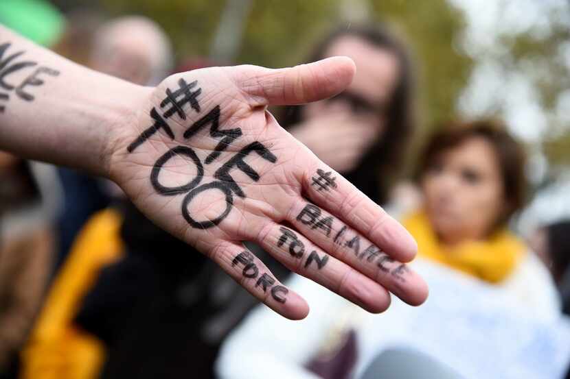 A picture shows the message "Me too" on the hand of a protester during a gathering against...