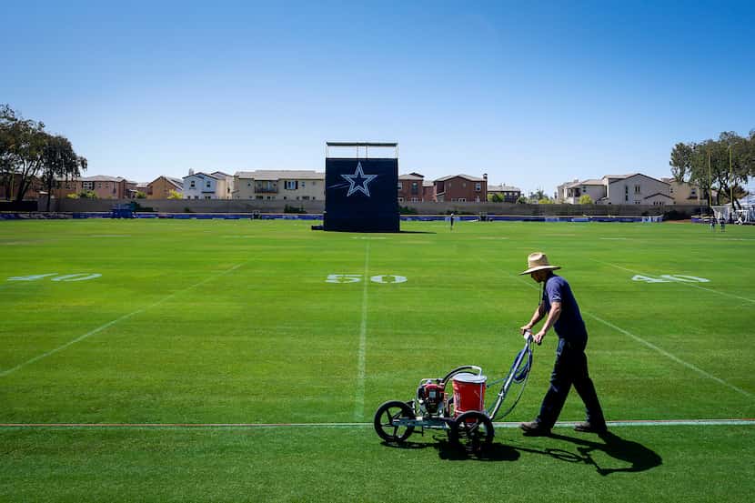 Groundskeepers stripe the field in preparation for opening of Dallas Cowboys training camp...